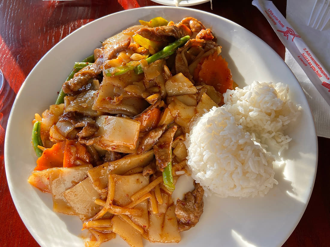 Wok plate with wide rice noodles, vegetables and steamed rice at Basil Viet Kitchen