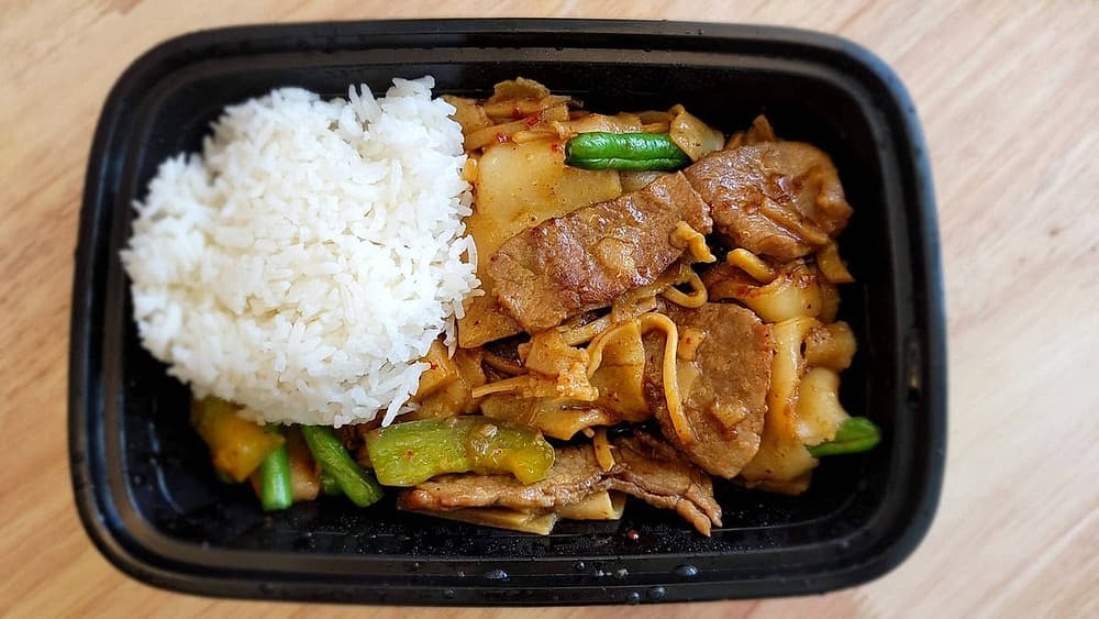 Takeout container with rice and stir-fried noodles from Basil Viet Kitchen